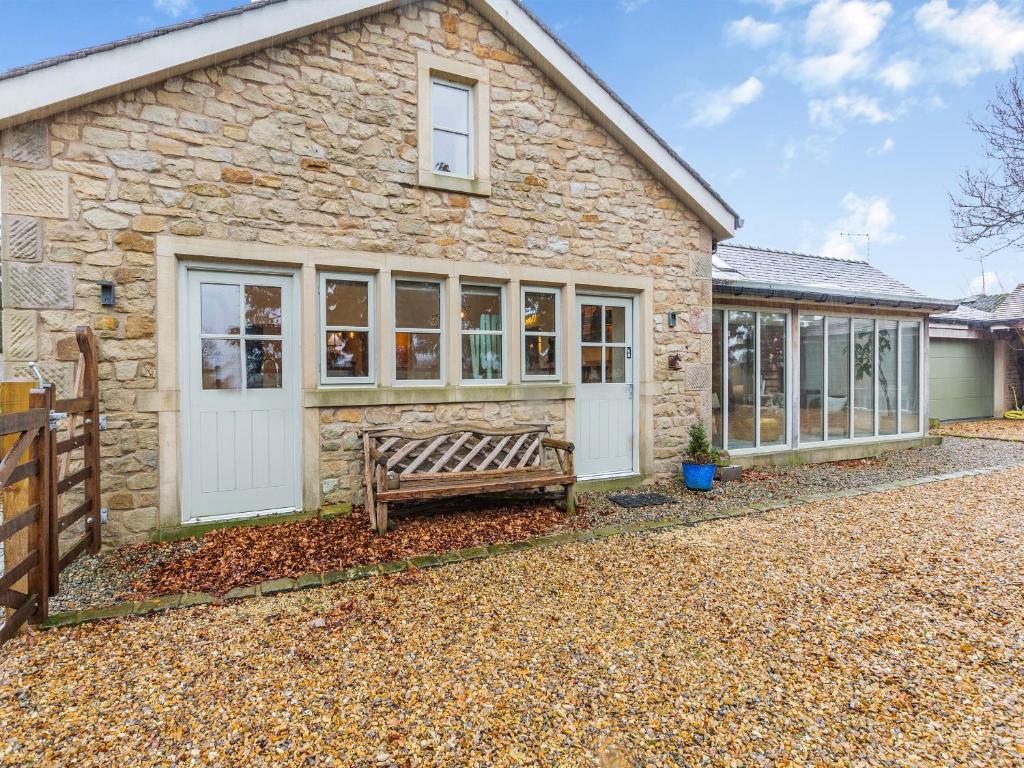 a stone house with a bench in front of it at The Stables in Longridge