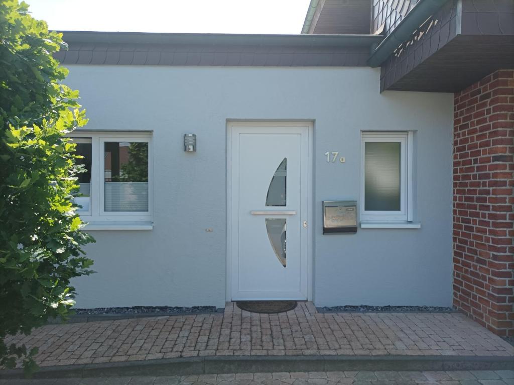 una puerta blanca en una casa blanca con una ventana en Ferienwohnung Am Stadtfeldgraben en Telgte