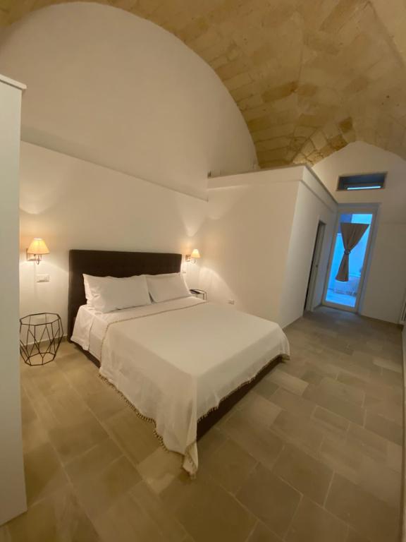 a bedroom with a white bed and a window at Dadaumpa suite in Lecce