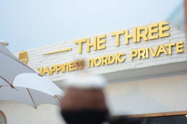 una señal en el lateral de un edificio con una sombrilla en The3 Happiness Nordic Private Home, en Nakhon Phanom