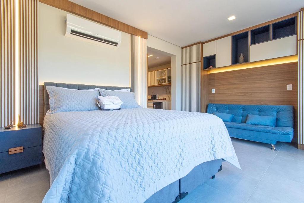 - une chambre avec un lit bleu et un canapé bleu dans l'établissement ILE de Pipa Resort Quarto Superior Frente Piscina, à Pipa