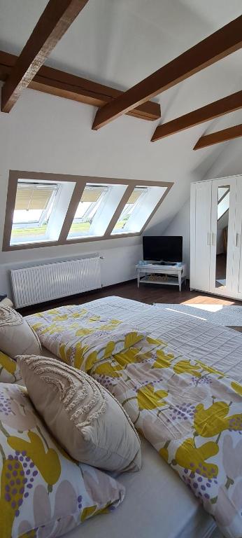 a bedroom with two beds in a room with windows at Lille hygge in Leck