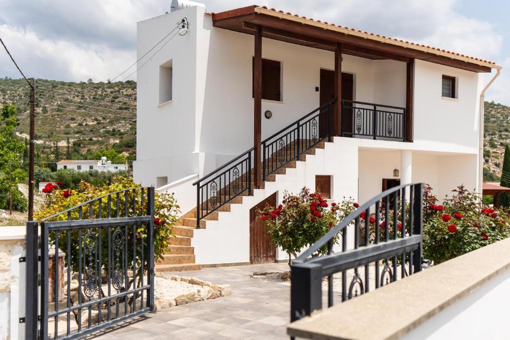 a white house with stairs and flowers at Steni Traditional Studio Apartment in Paphos