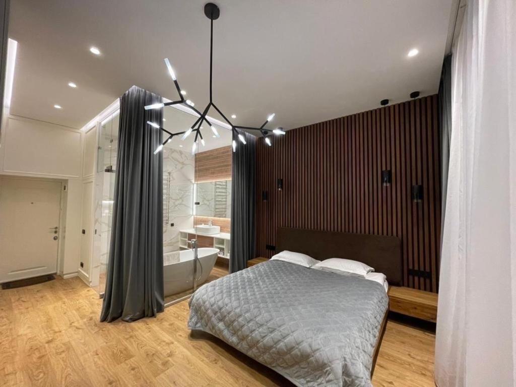 a bedroom with a bed and a bath tub and a bed istg at Doroshenka Premium Apartments in Lviv