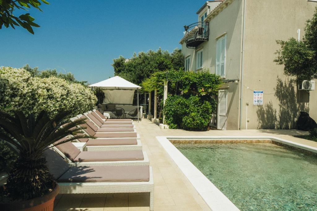 una casa con piscina al lado de un edificio en Deluxe apartment Marghareta, en Dubrovnik