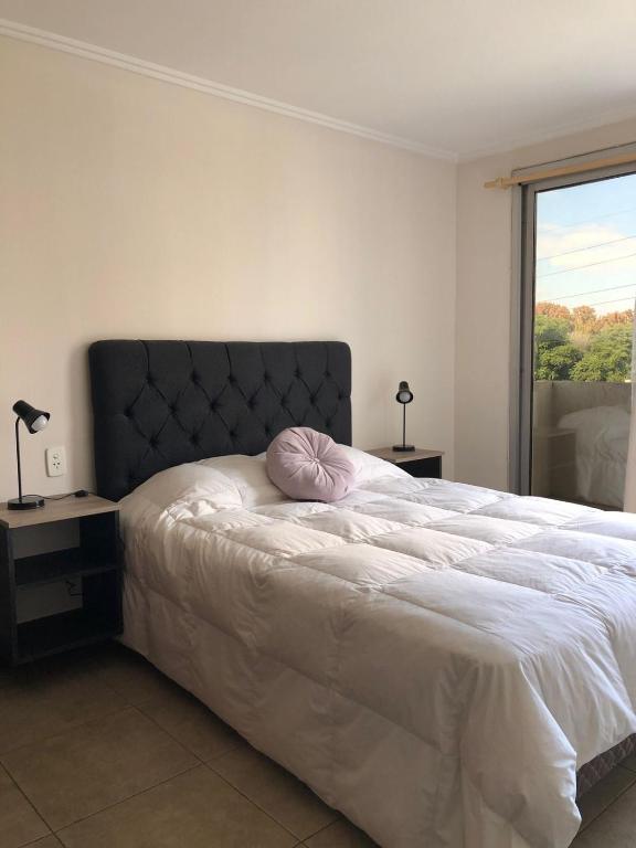 Dormitorio con cama con almohada rosa en Amplio departamento en quinta sección en Mendoza