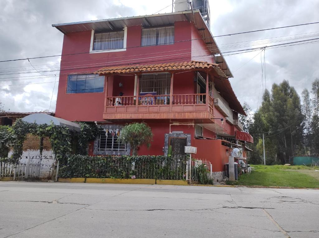 una casa rossa con balcone su una strada di Baños del. Inca a Lima