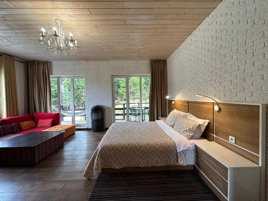 Парк-готель Щастя في سكيدنيستا: غرفة نوم مع سرير وغرفة معيشة مع أريكة