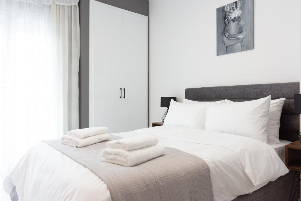 um quarto com uma cama branca e toalhas em SKG Dream Residence em Tessalônica