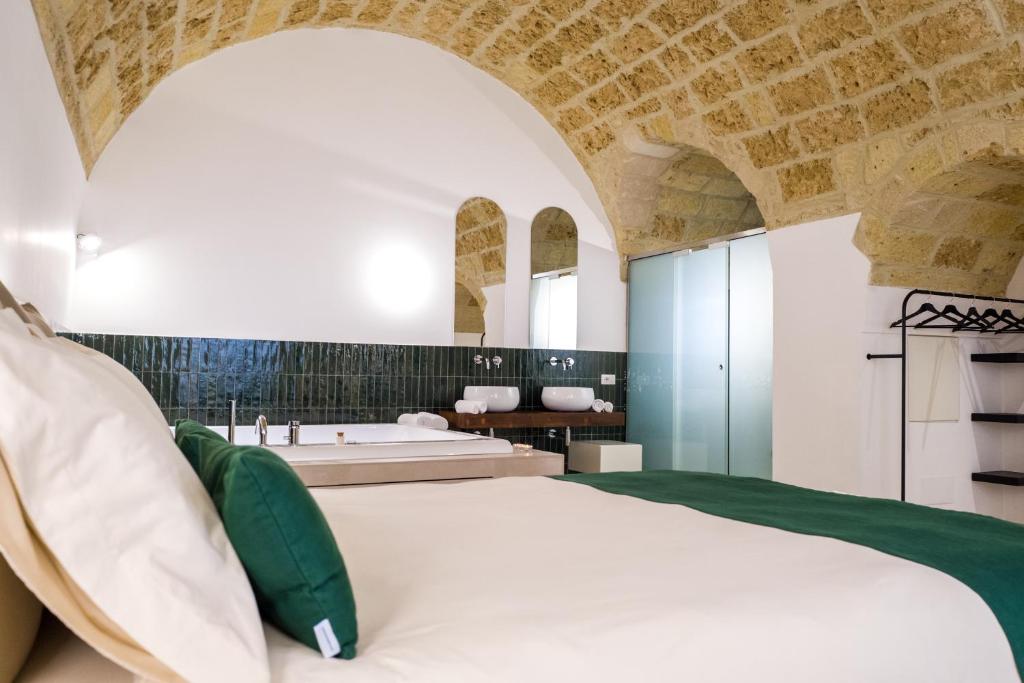 a bedroom with a large bed and a bathroom at Casa Minerva - Suite e Relax in Gioia del Colle
