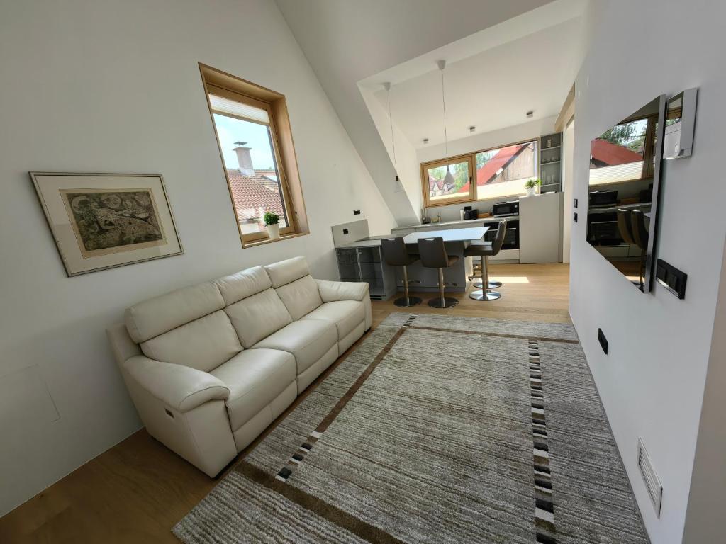 a living room with a white couch and a rug at V22 - Premium Apartements in Ljubljana