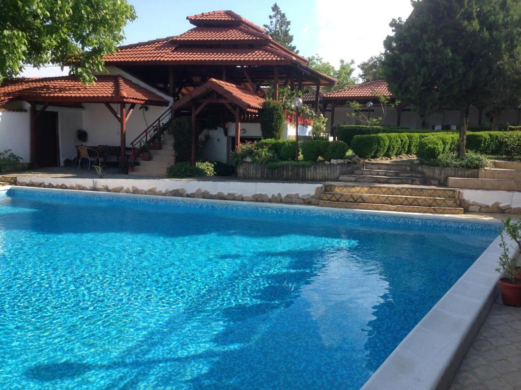 a swimming pool in front of a house with a gazebo at Family Hotel Accent in Razgrad