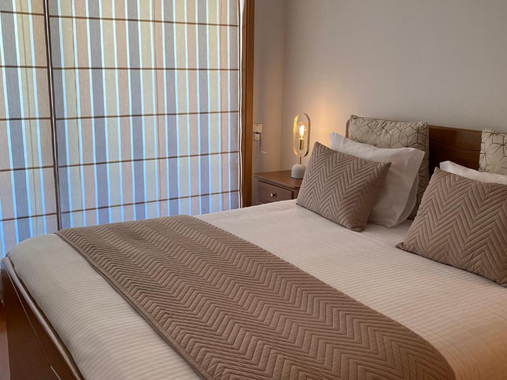 una camera da letto con un grande letto con due cuscini di Viseu Home a Viseu