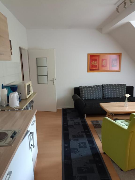 a kitchen and living room with a couch and a table at Nette Kuschelige Wohnung in Bochum
