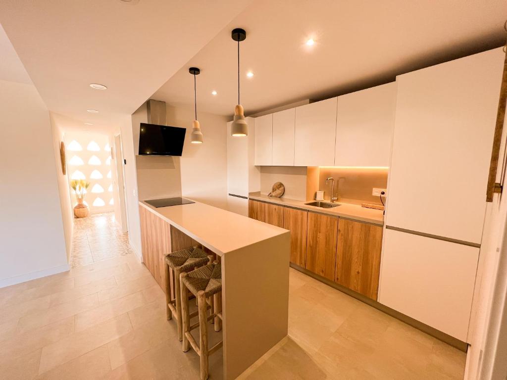 a kitchen with white cabinets and a counter top at Apartamentos Nogal in Aguadulce