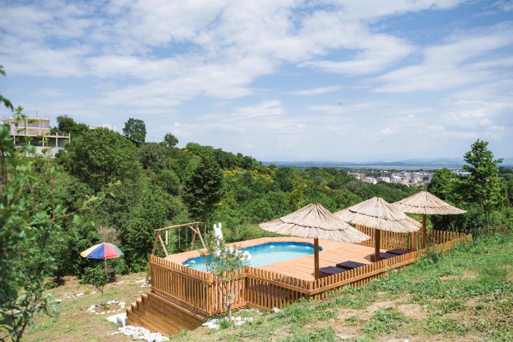 a swimming pool with two umbrellas and a swimming poolvisor at Madre Natura Glamping in Ulcinj