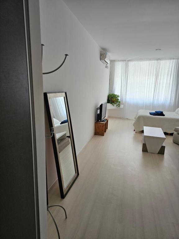 Habitación blanca con espejo y cama en LaMari en Buenos Aires