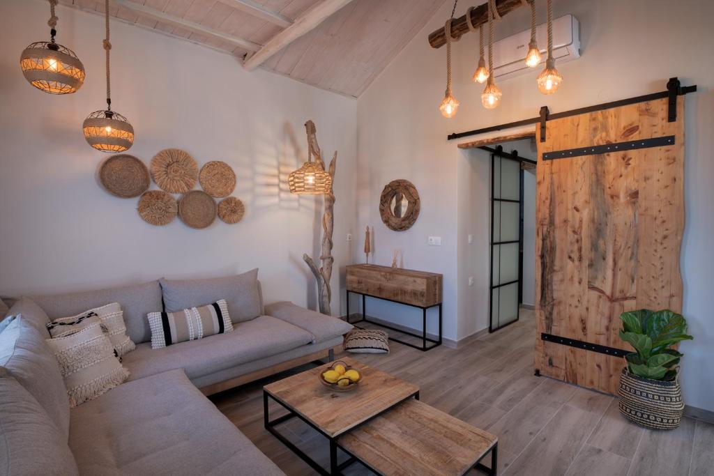 a living room with a couch and a wooden door at Chora Suite in Alonnisos