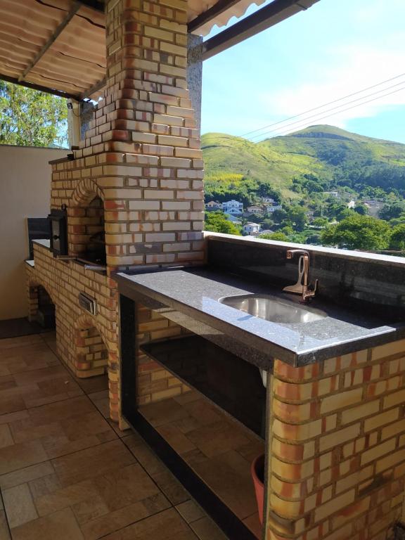 a kitchen with a sink and a brick oven at Casa da Montanha in Miguel Pereira