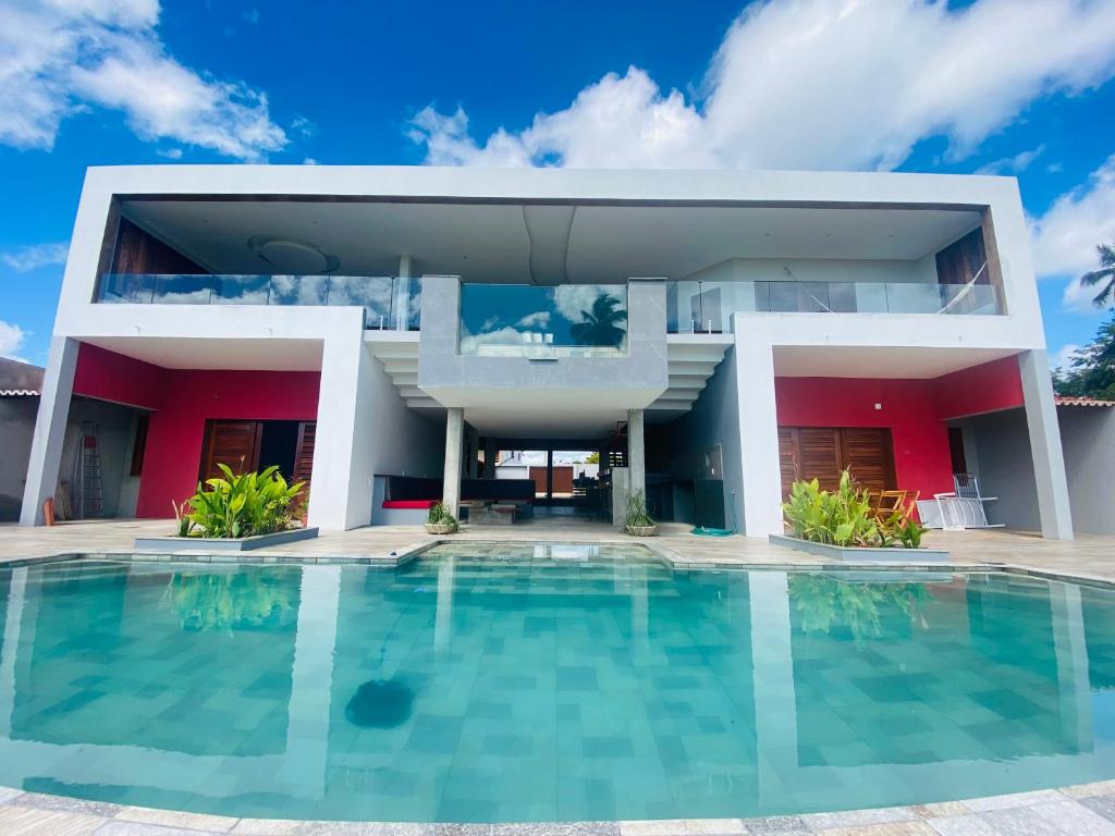 une maison avec une piscine en face de celle-ci dans l'établissement Vila Kite Lagoon, à Parajuru