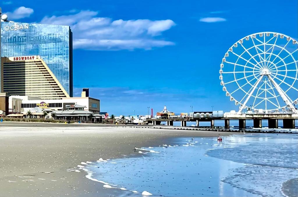 - une plage avec une grande roue et un complexe dans l'établissement 3 Bedrooms, Boardwalk Duplex Beachblock Home!, à Atlantic City