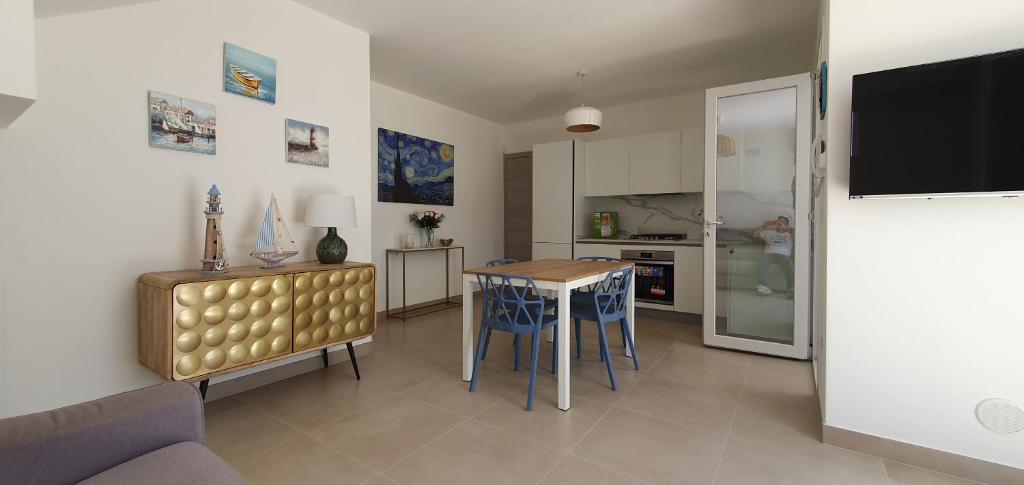 cocina y sala de estar con mesa y sillas en La Dimora del Salento, en Torre Lapillo