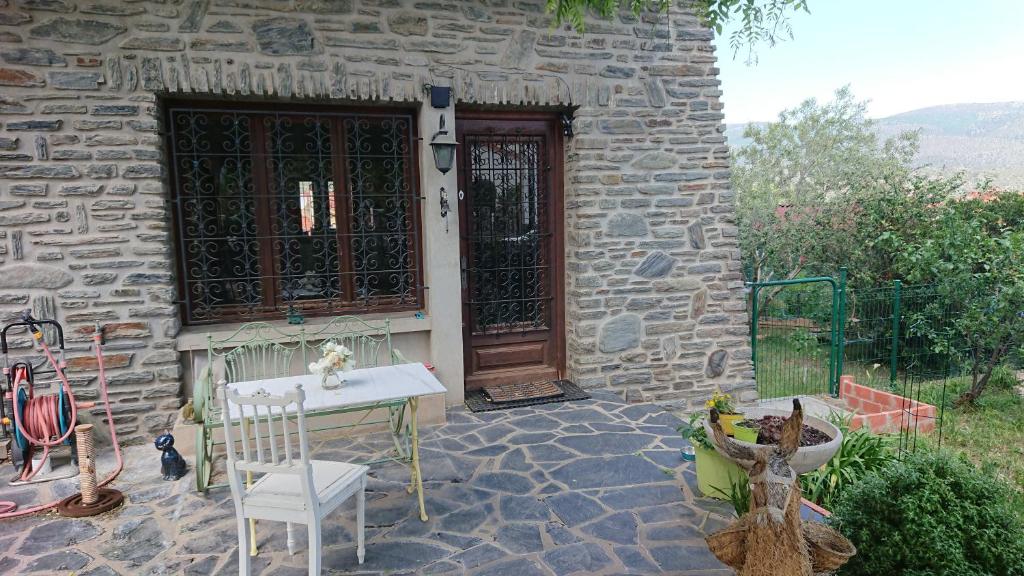 une maison en pierre avec une table devant une porte dans l'établissement appartement en rez de jardin CYCLISTES BIEN VENUS, à Prades
