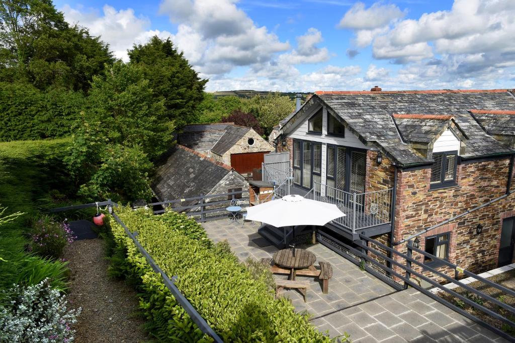 an aerial view of a house with a patio with an umbrella at Tranquil Cornish retreat close to Port Isaac beaches and moor in Bodmin