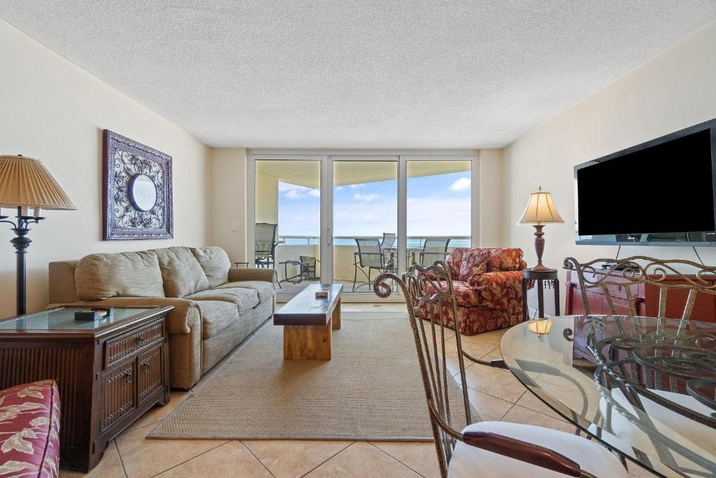 a living room with a couch and a table and a television at Perdido Sun 610 in Perdido Key