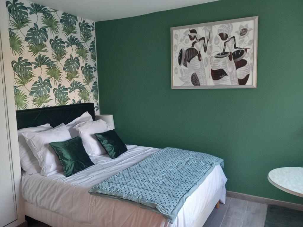 a bedroom with a bed with a green wall at Le Cocon Vert in Rueil-Malmaison