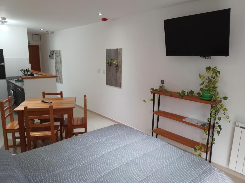 Habitación con cama, mesa y TV. en Departamento Centrico Ana en Ushuaia