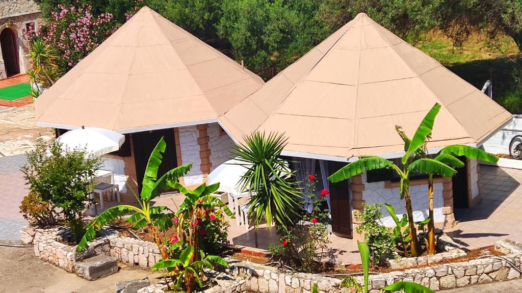 a small building with a large tan umbrella at Spasmata Marios bungalows in Minia