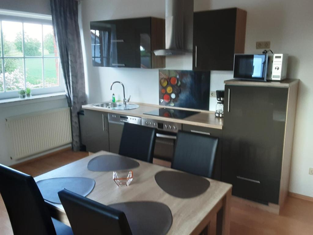a small kitchen with a table and a refrigerator at Stadt-Land-Fluss in Wickede (Ruhr)