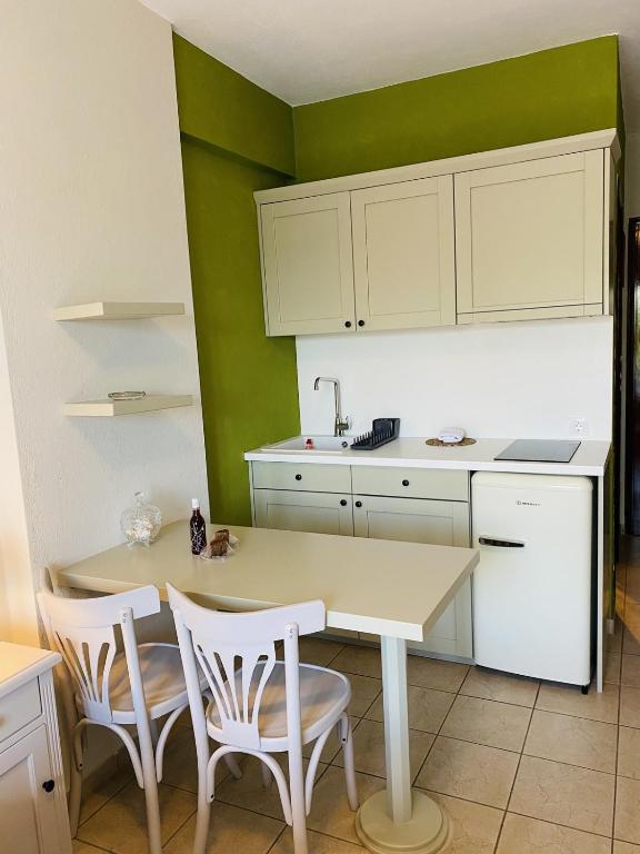 eine Küche mit einem Tisch, Stühlen und einem Waschbecken in der Unterkunft Harmony Seaside Pelion in Platanias