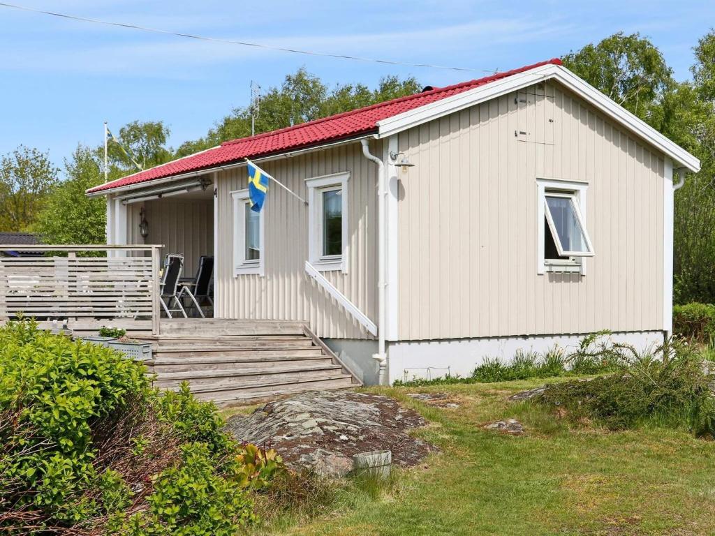 uma pequena casa branca com um deque de madeira em Holiday home VARBERG XXI em Varberg