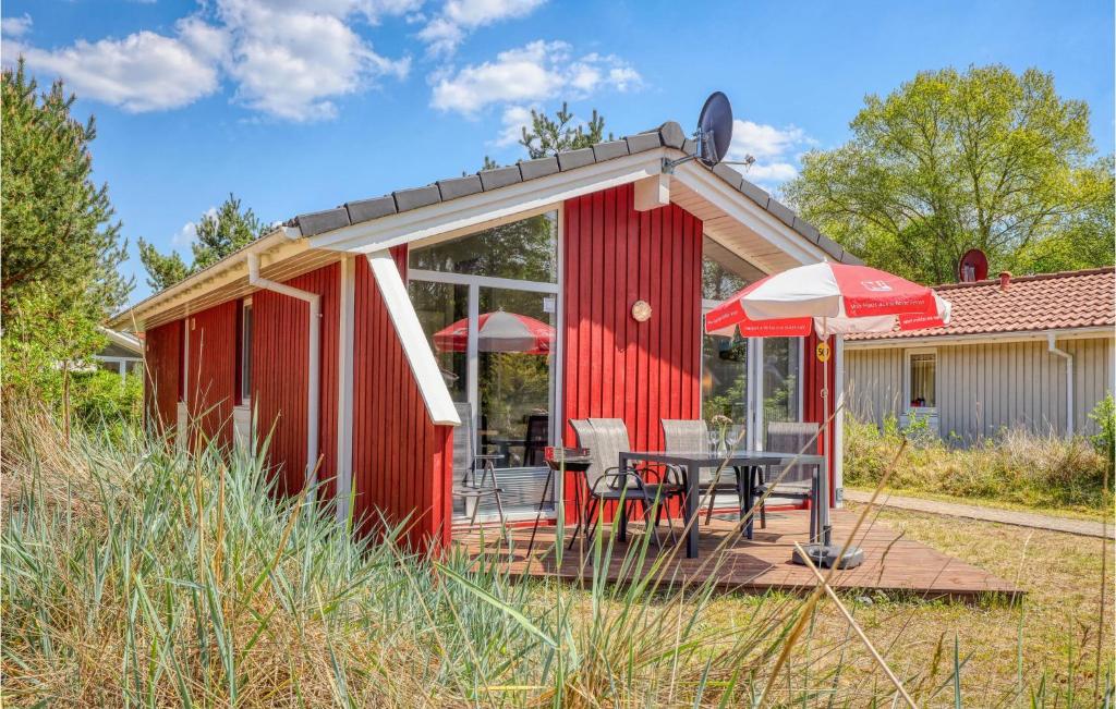 a red shed with a table and an umbrella at Schatzkiste 9 - Dorf 4 in Travemünde