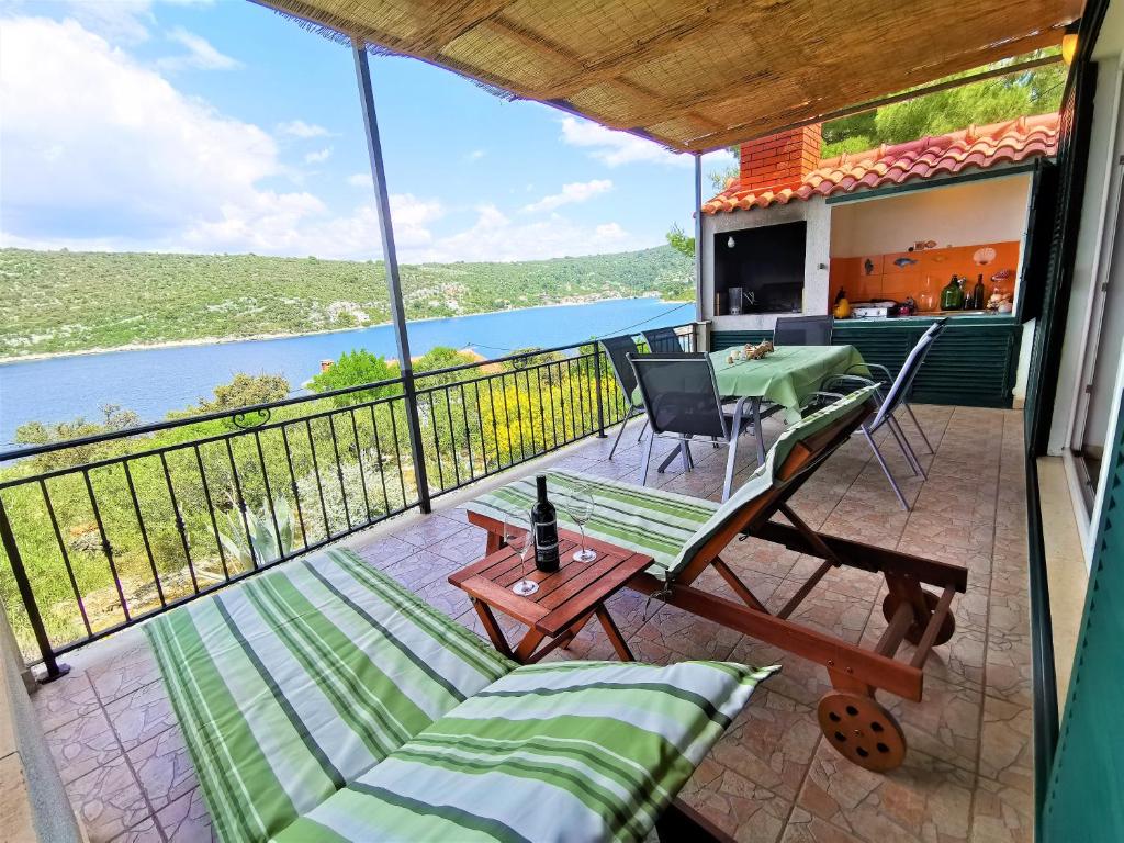balcón con mesa, sillas y vistas al agua en Holiday Home Villa Marela, en Veliki Drvenik