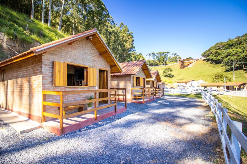 uma fila de casas rústicas numa estrada de cascalho em Pousada Sonho Meu em Camanducaia