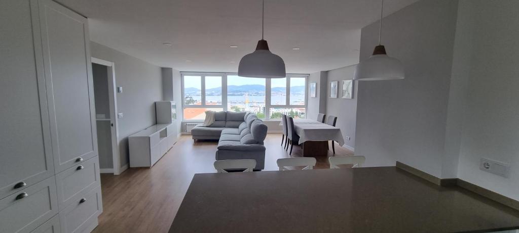 Sala de estar blanca con sofá y mesa en Vigo al Mar, en Vigo