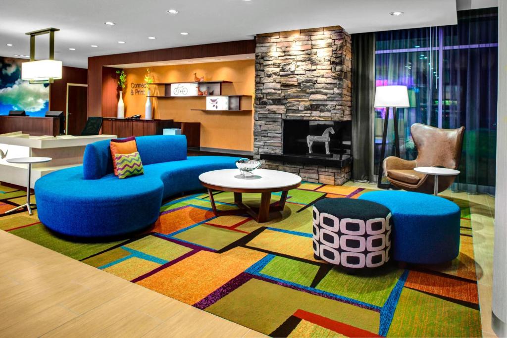 a living room with blue furniture and a fireplace at Fairfield Inn & Suites by Marriott Douglas in Douglas
