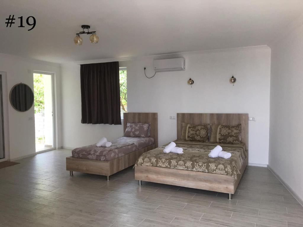 um quarto com duas camas e um sofá em Rezo's House em Kvariati