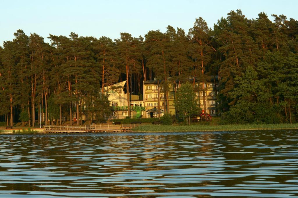 una gran casa en la orilla de un cuerpo de agua en Kompleks Rekreacyjny KNIEJA w Rajgrodzie, en Rajgród