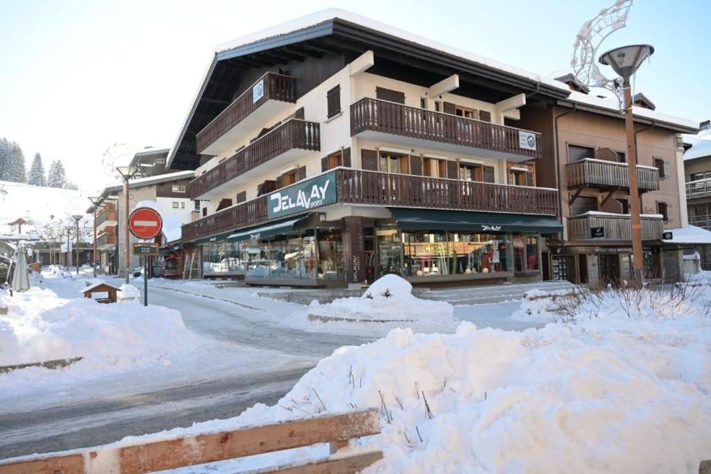 a building on a street covered in snow at Résidences Delavay Les Pistes in Les Gets