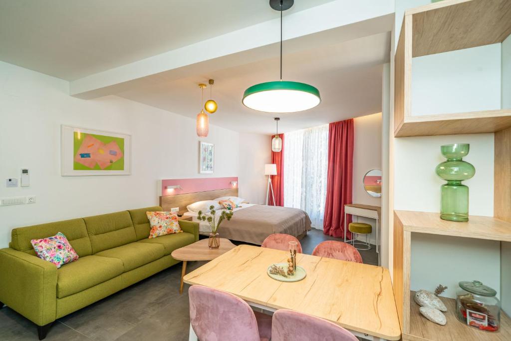 un soggiorno con divano verde e tavolo di Apartments Olea a Cavtat