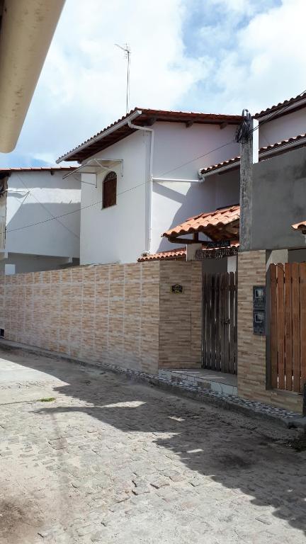 una casa con una pared de ladrillo y una valla en Casa da Ilha de Boipeba, en Isla de Boipeba