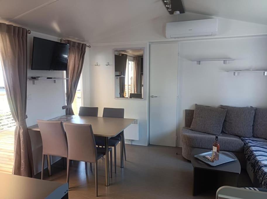 un salon avec une table et un canapé dans l'établissement Mobil-Home FO 30 à Vias - La Carabasse - Camping Siblu avec piscine, à Vias