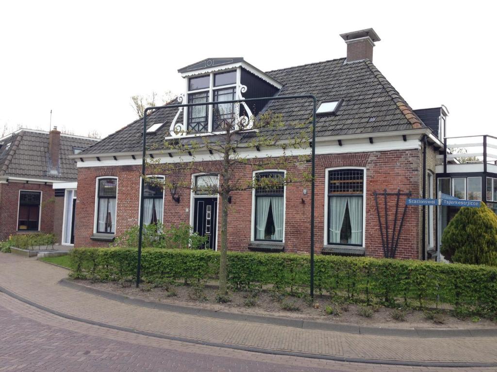 a brick house with a balcony on top of it at De Rede in Molkwerum