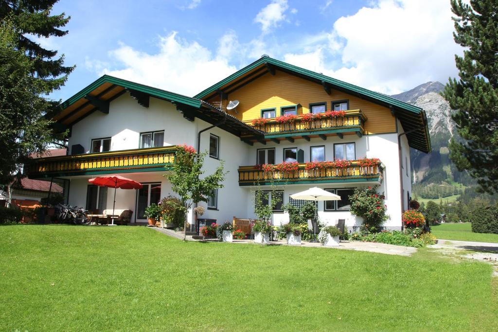 une grande maison avec une pelouse devant elle dans l'établissement Apartmenthaus Dornröschen, à Ramsau am Dachstein