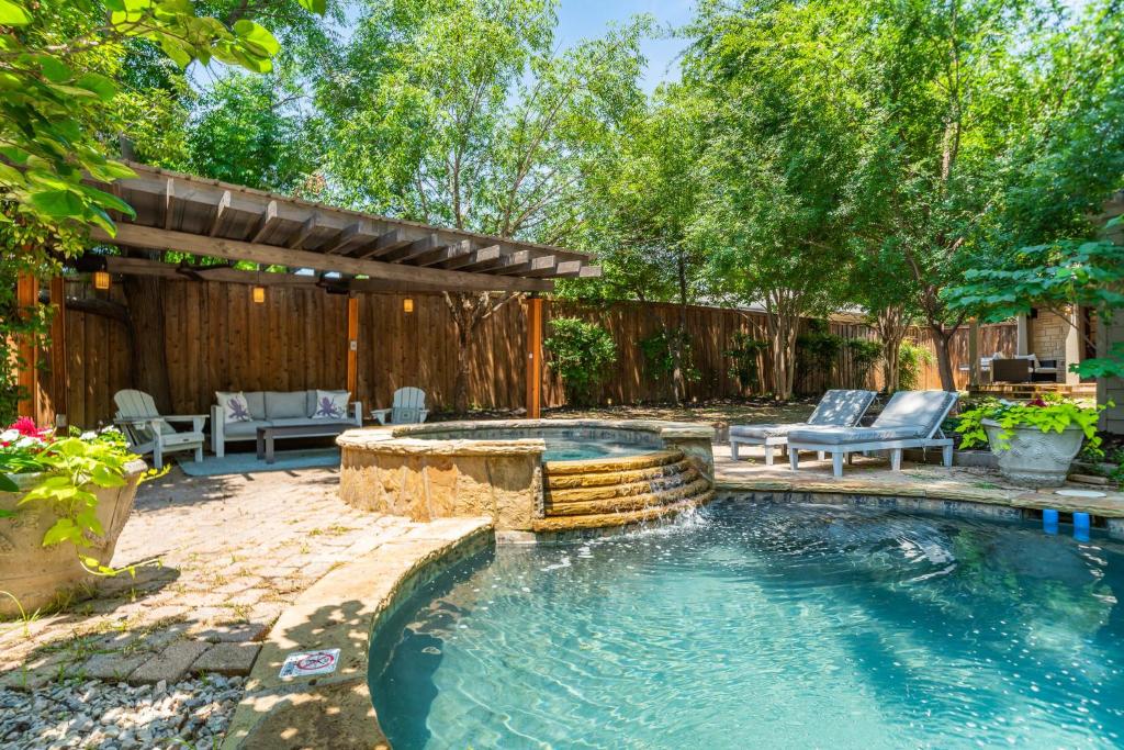 un patio trasero con piscina y pérgola en Sunset House - Luxury Pool and Hot Tub Retreat en Dallas