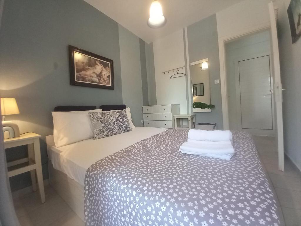 a bedroom with a bed with a blue and white comforter at Vasiliki Holidays Private Apartment Chalkidiki in Flogita
